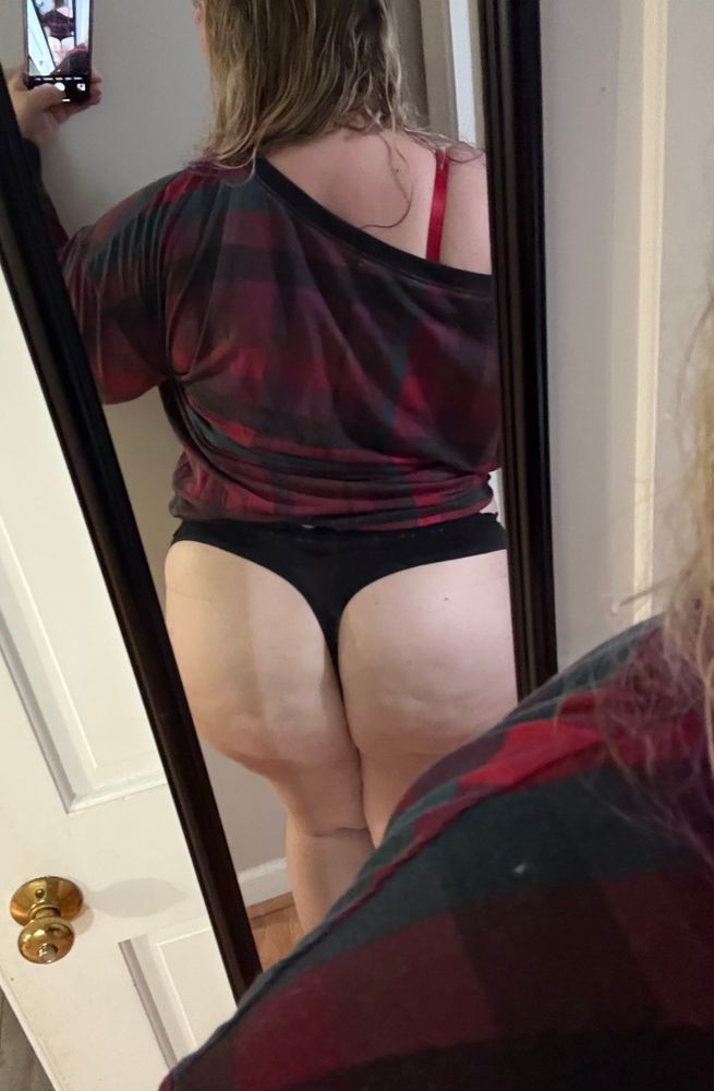 A mirror pic where my back is to the camera and you can see I’m wearing a plaid off-shoulder top and a thong
