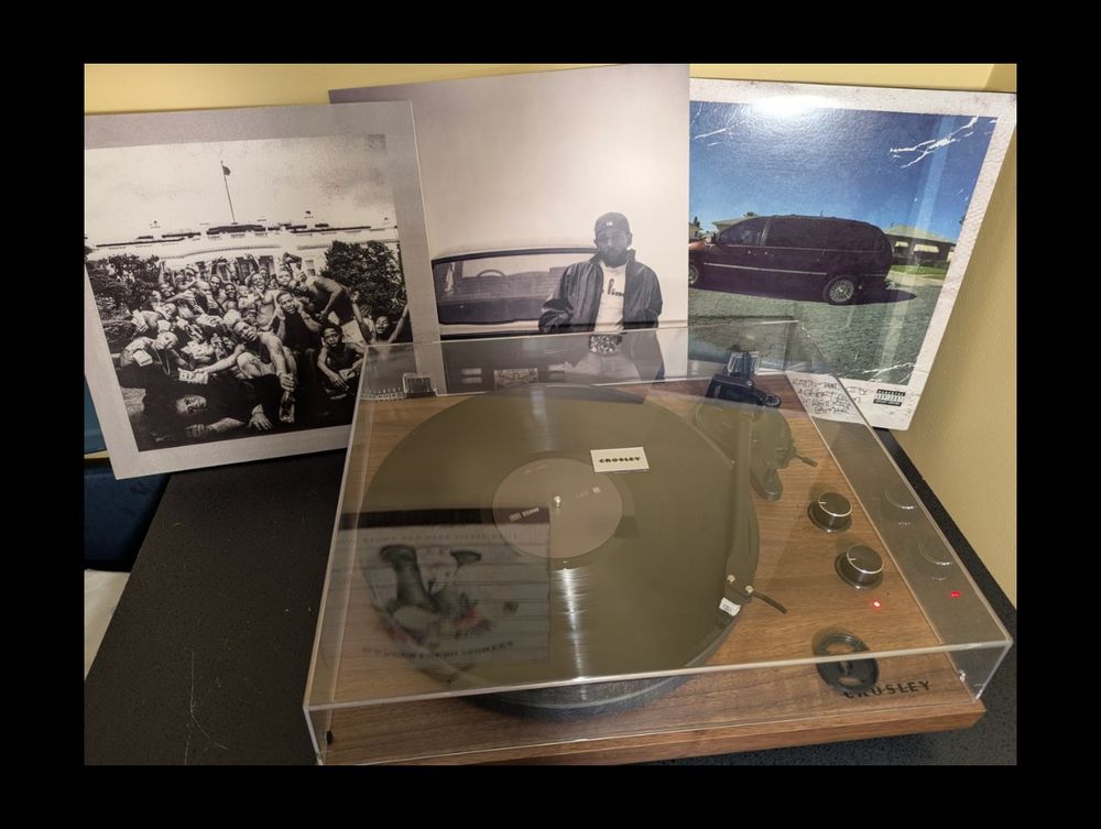 Record player spinning GNX with three Kendrick Lamar albums in the background. To Pimp a Butterfly, GNX, good kid, mAAd city