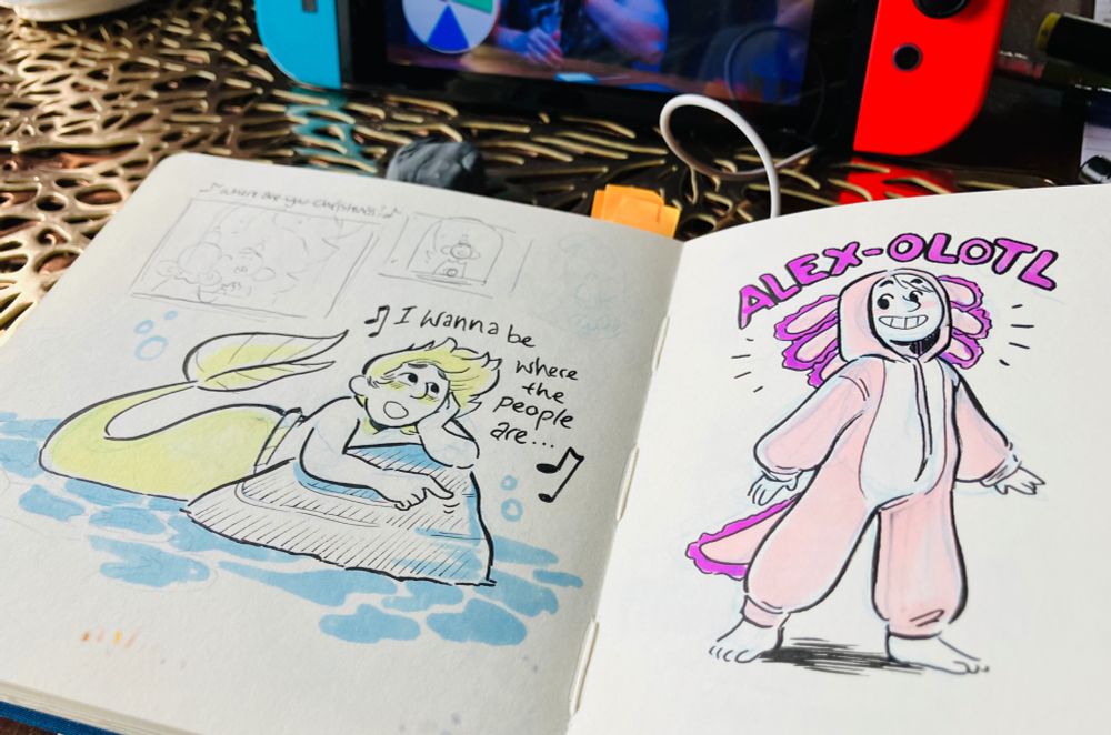 A photo of a square sketchbook spread. 
On the left is a green and blue drawing of Alex as Ariel, leaning against a rock singing “I wanna be where the people are…” 
On the right is Alex in an axolotl onesie, with pink and purple tones. ALEX-OLOTL is written in bubble letters above her.