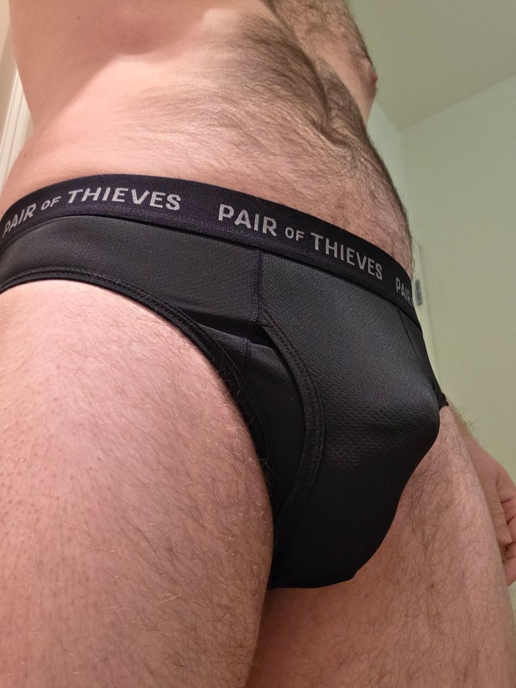 A close up of Oli wearing black briefs