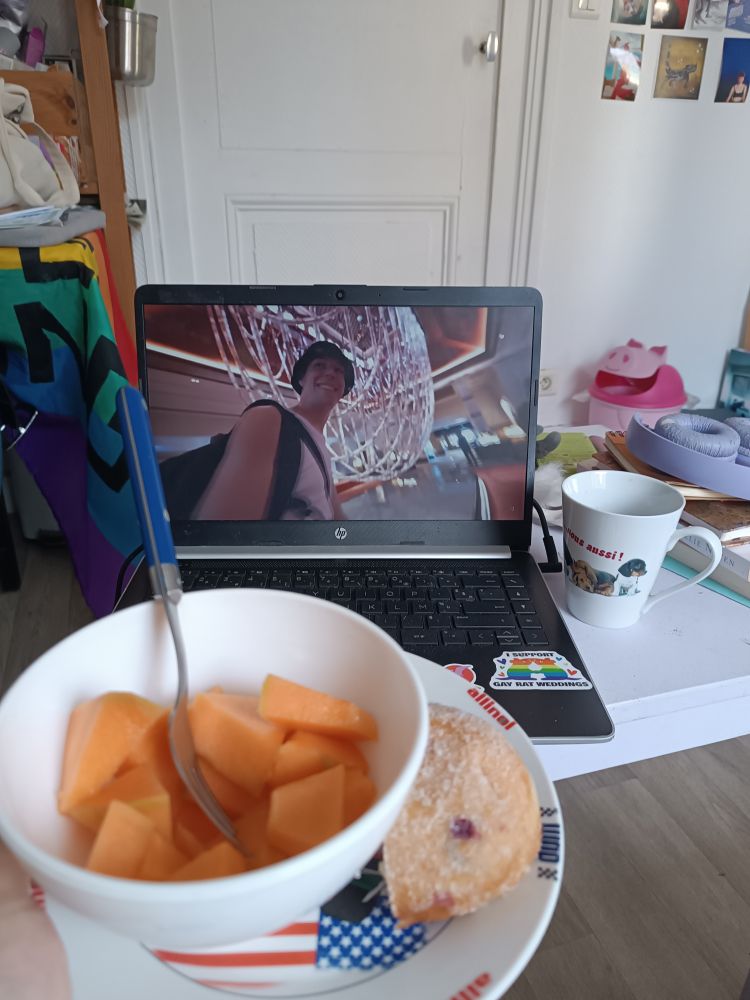 Bol de melon et moitié de donut fourré à la confiture de myrtille devant un vlog d'août de lena situations 
