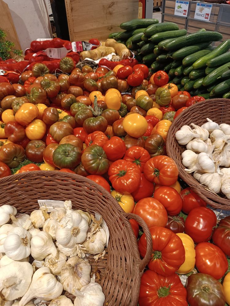 Plein de tomates, concombres et oignons posés à l'intérieur d'un supermarché 