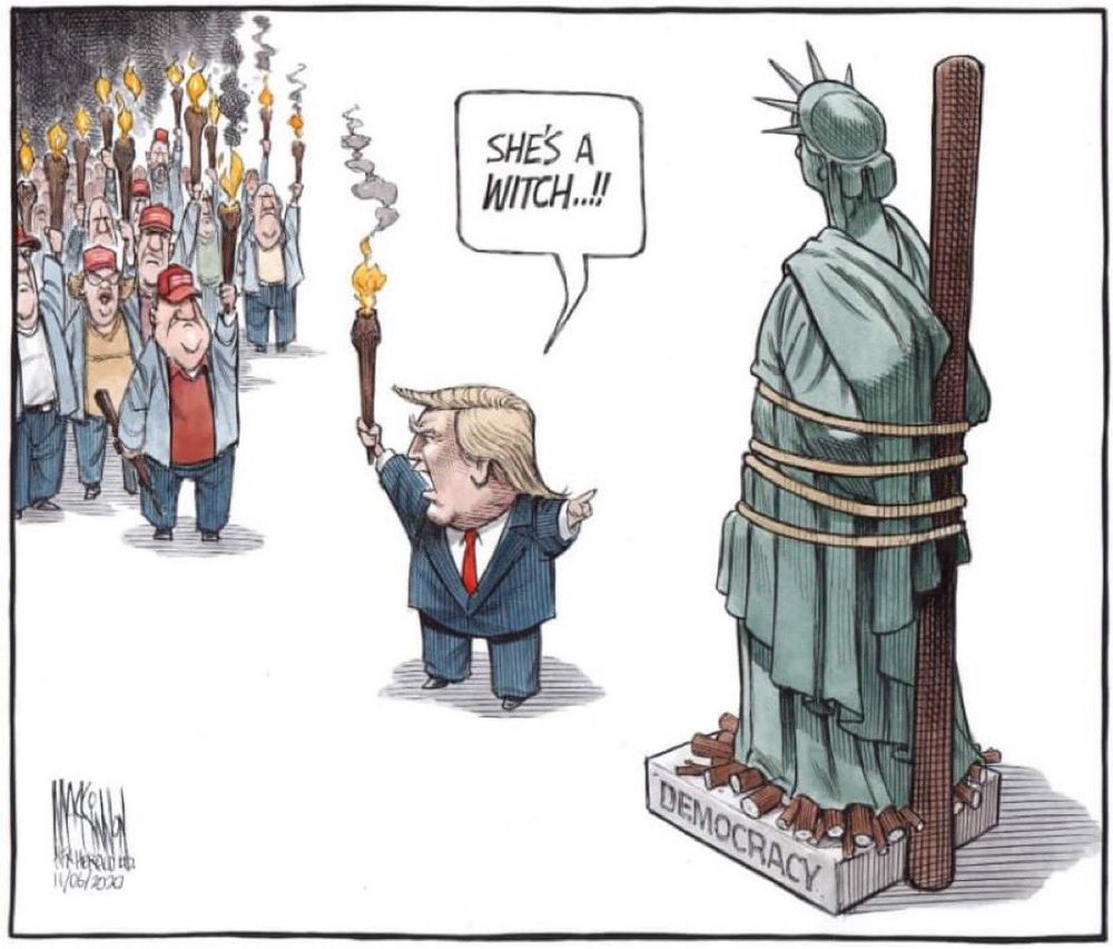 Trump pointing at lady liberty tied to a stake, caption reads "she's a witch" and there's a crowd of supporters with torches ready to burn democracy. 