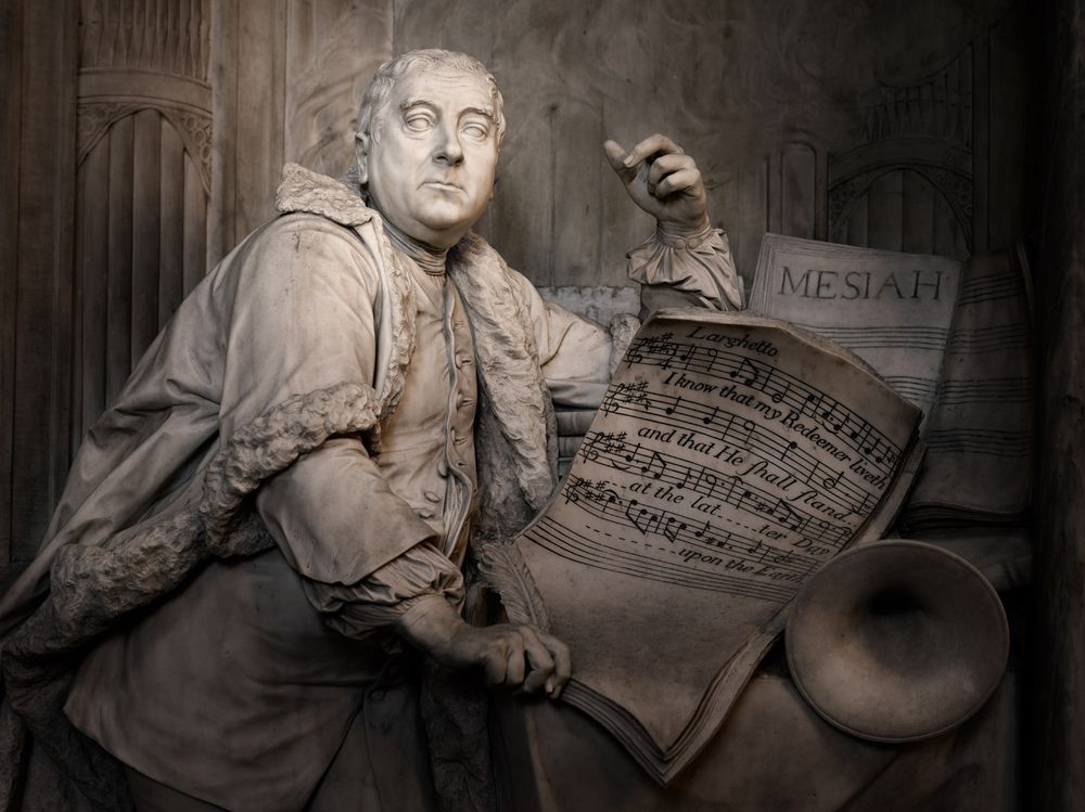 A statue of George Frideric Handel in Westminster Abbey, depicting the composer standing and holding a copy of the score for his oratorio, Messiah