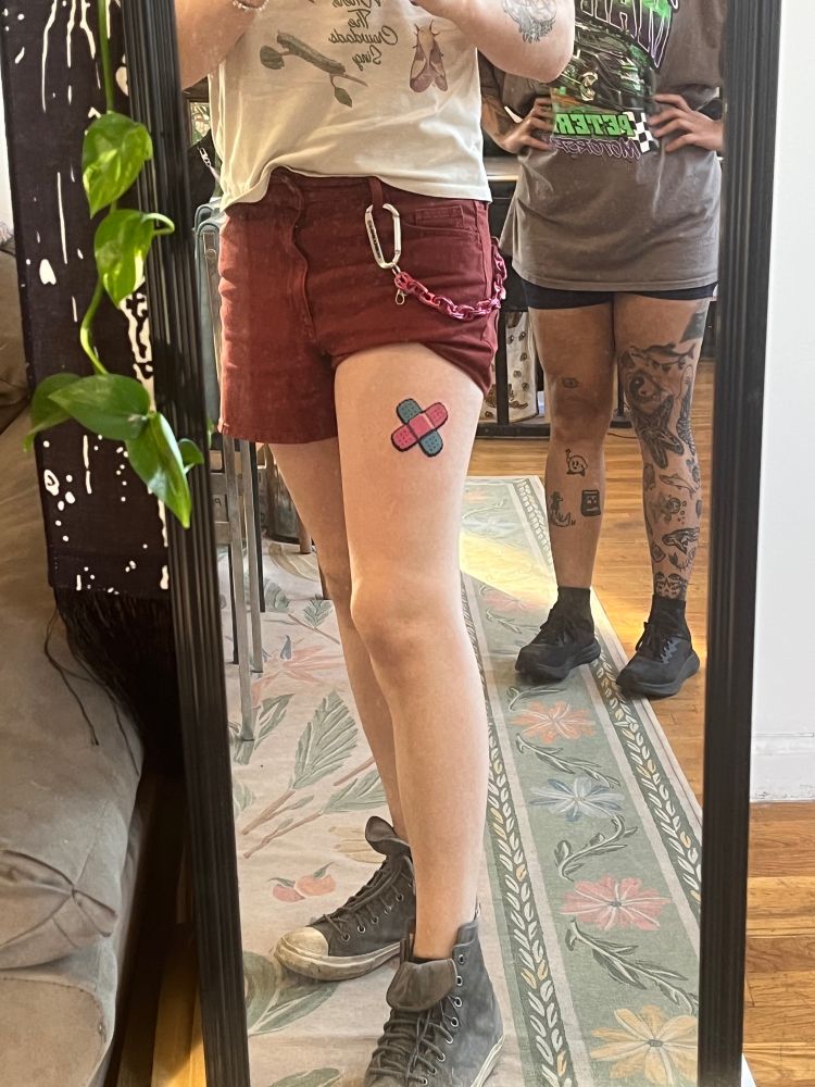 Pink and blue pixel tattoo on a thigh