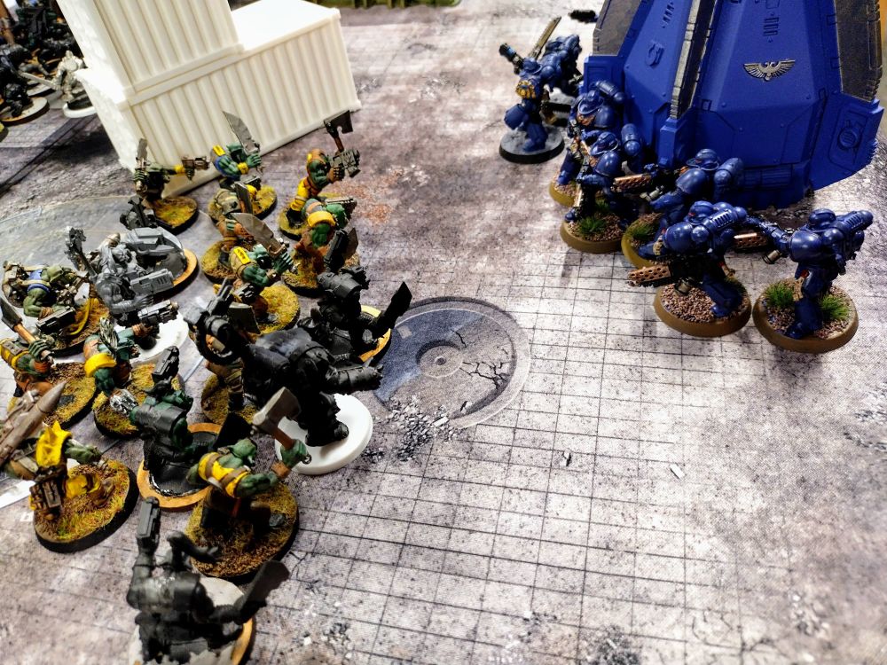 An ultramarine drop pod lands in the Ork Deployment zone