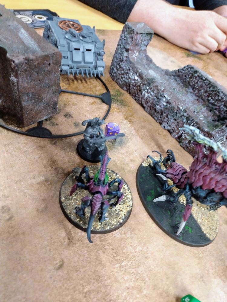 The remaining Tyranid units try to claim an objective held by a noise marine and a rhino