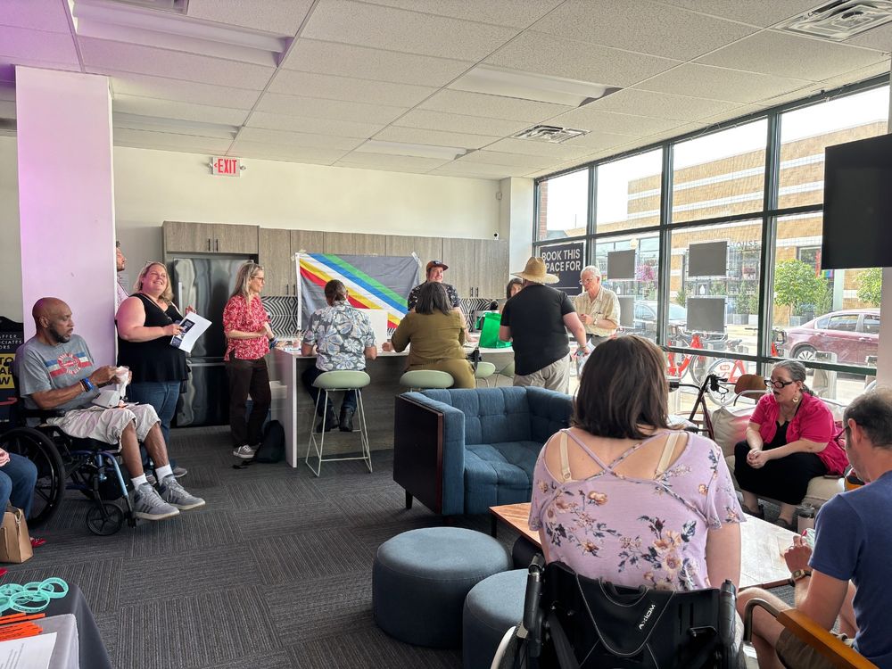 Fourteen people spread around the room enjoying the event.