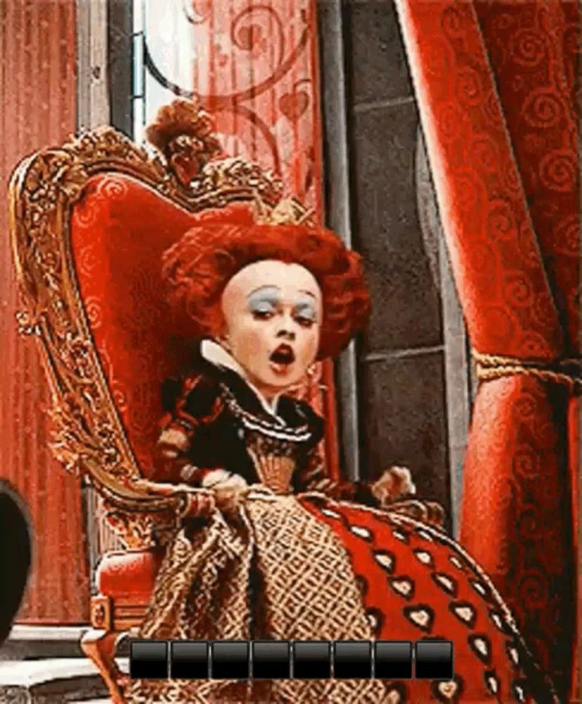 queen of hearts from alice in wonderland sitting in a chair