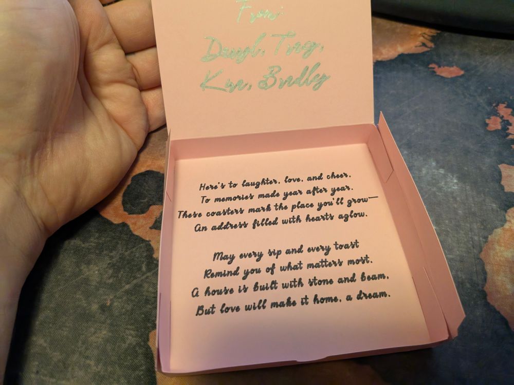 A pink coaster box without the coasters. There's a poem written on the bottom of the box