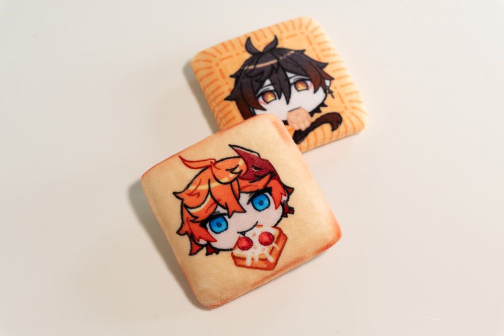 product image of 2 plush badges featuring Tartaglia and Zhongli from the game Genshin Impact - Tartaglia is the badge in the front