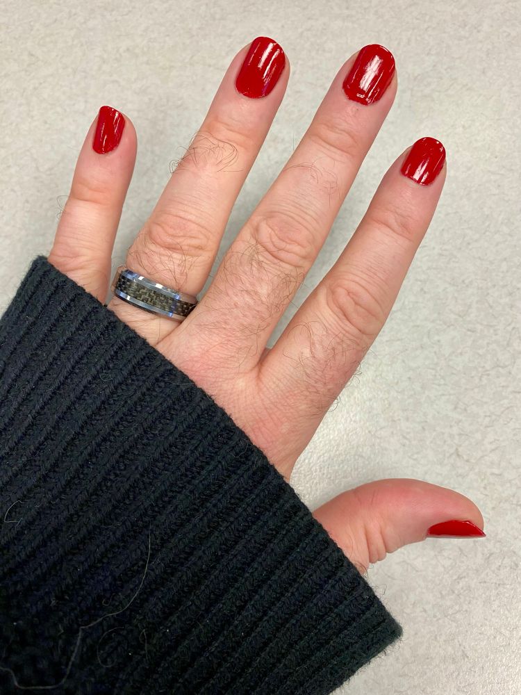 My left hand showing bright red nail polish on each finger. 