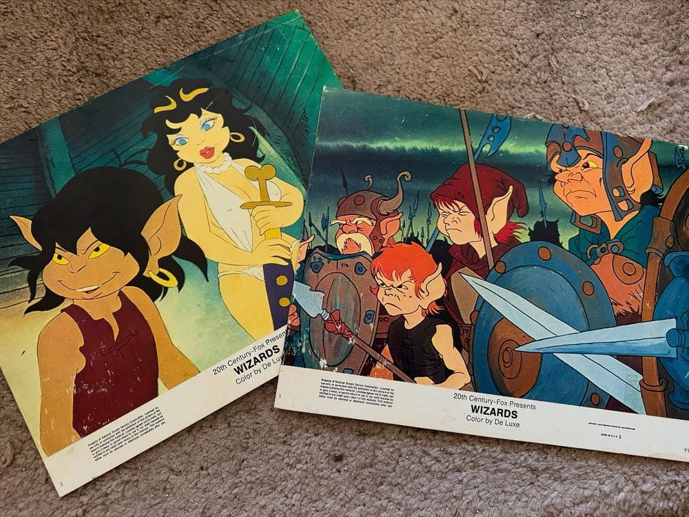 Two lobby cards for the 1977 Ralph Bakshi animated movie Wizards, each depicting a scene from the movie. 