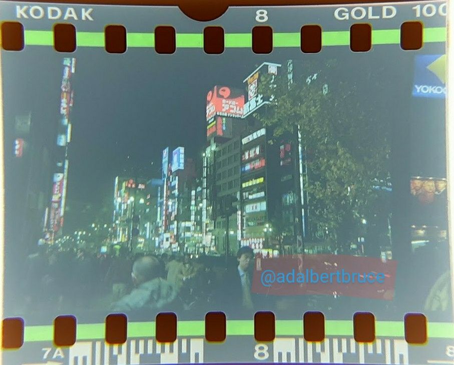 A proliferation of neon, tall buildings, and passersby at night in Tokyo. -JBF 