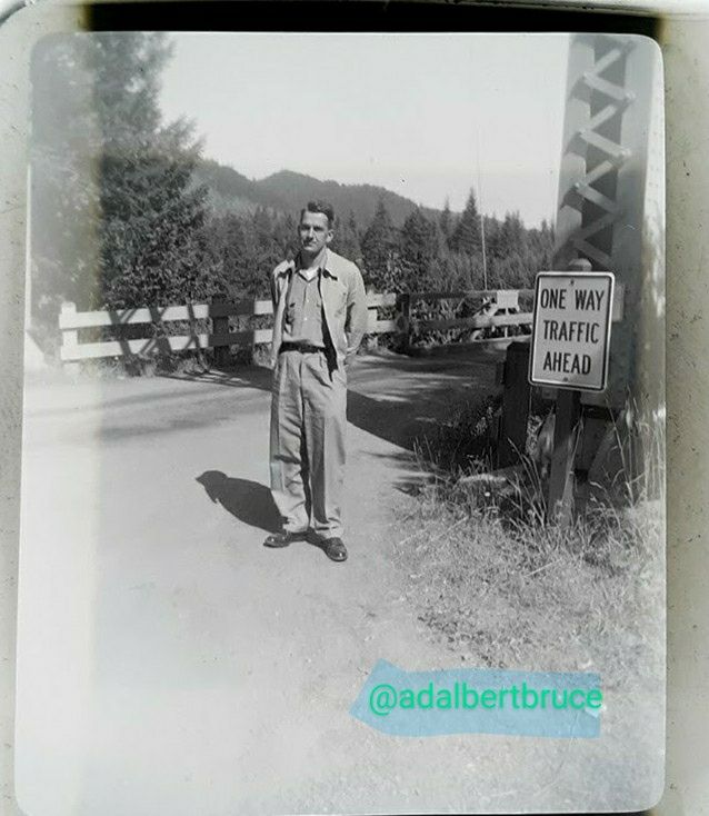 Bruce W. Falk; standing with arms behind his back, by a traffic sign; and bridge support. -JBF 