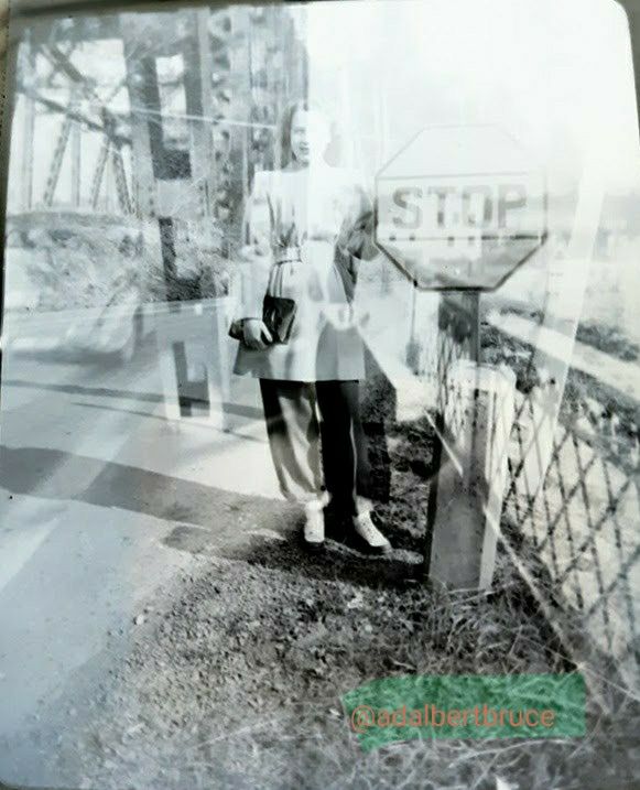 A montage I made, by combining two 1940s negatives, of and by Hazel M. Falk; showing her smiling, standing by a stop sign- appearing to be on a bridge. -JBF 