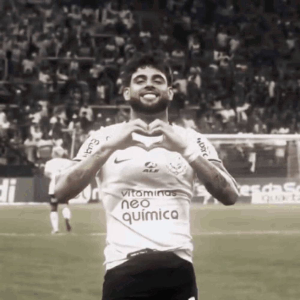 a soccer player wearing a neo quimica shirt makes a heart with his hands