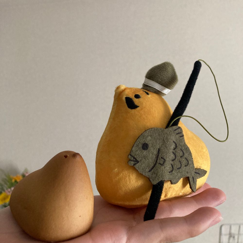 手のひらにのせたひよこ饅頭と、ひよこ饅頭が恵比寿のコスプレをしてるぬいぐるみの写真