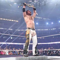 Hangman Adam Page standing tall at AEW All In holding the AEW Title above his head