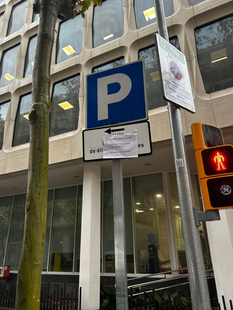Señal de parking exclusiva para juzgados con un cartel que dice “Basta de privilegios para los juzgados. Los vecinos necesitamos aparcar. No tenéis vergüenza!”