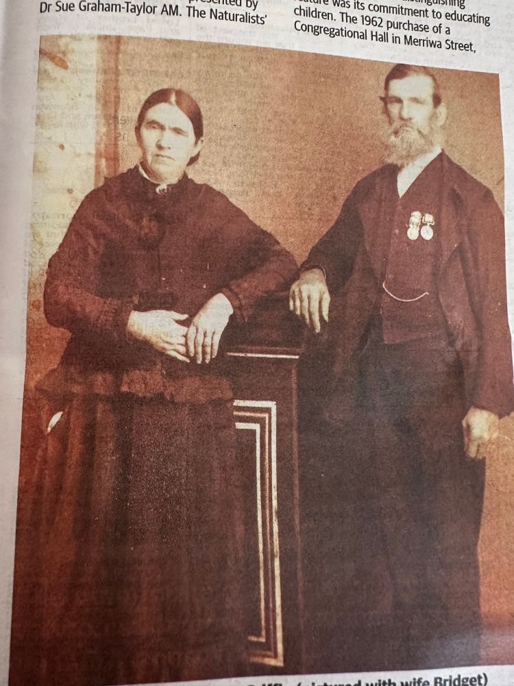 Sepia photo of married couple looking like they’d rather be eating scorpions than posing.