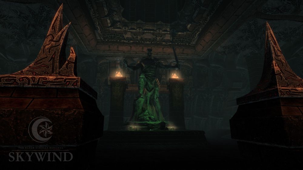 Interior picture of the Dushariran daedric ruin, showing a shrine with a large statue of Malacath, surrounded by pillars with lit braziers. He has Orc-like facial features, a muscular body, and is sparingly wearing armour pieces while holding up a sword with one hand.