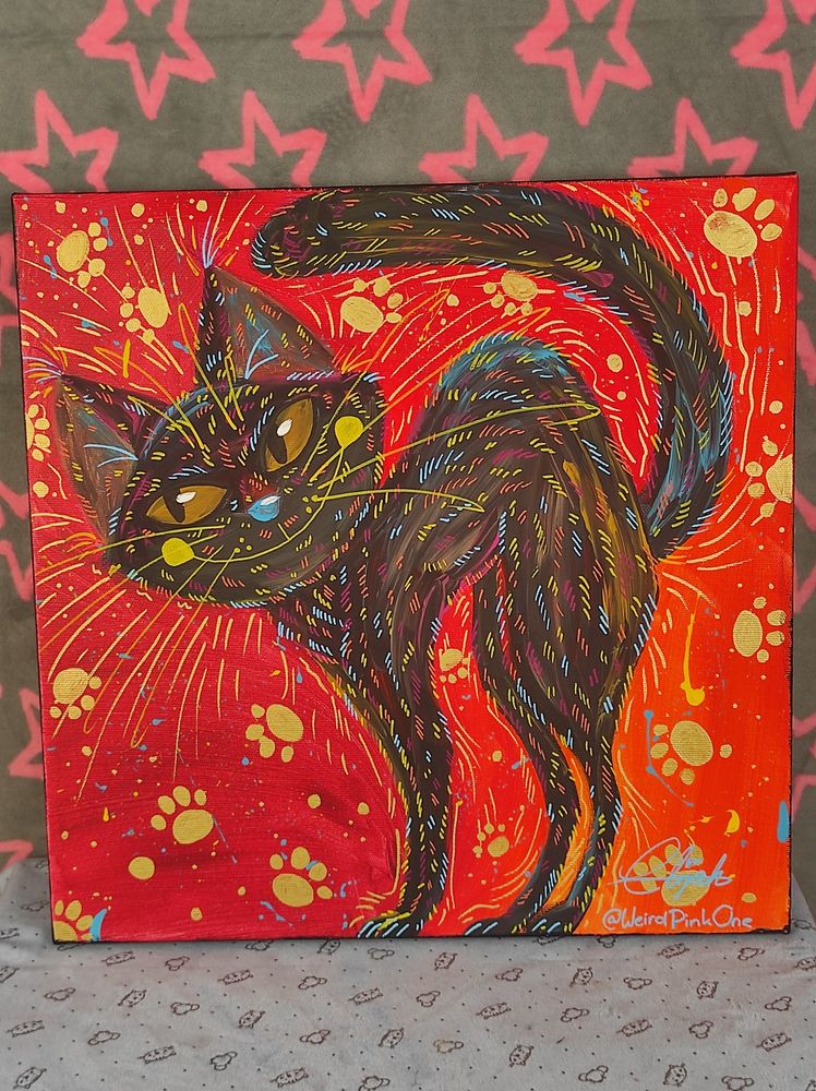 Arcyllic painting of a black cat with various colourful accents on a red background, that's spinkled in different colours and golden streaks and paw prints.