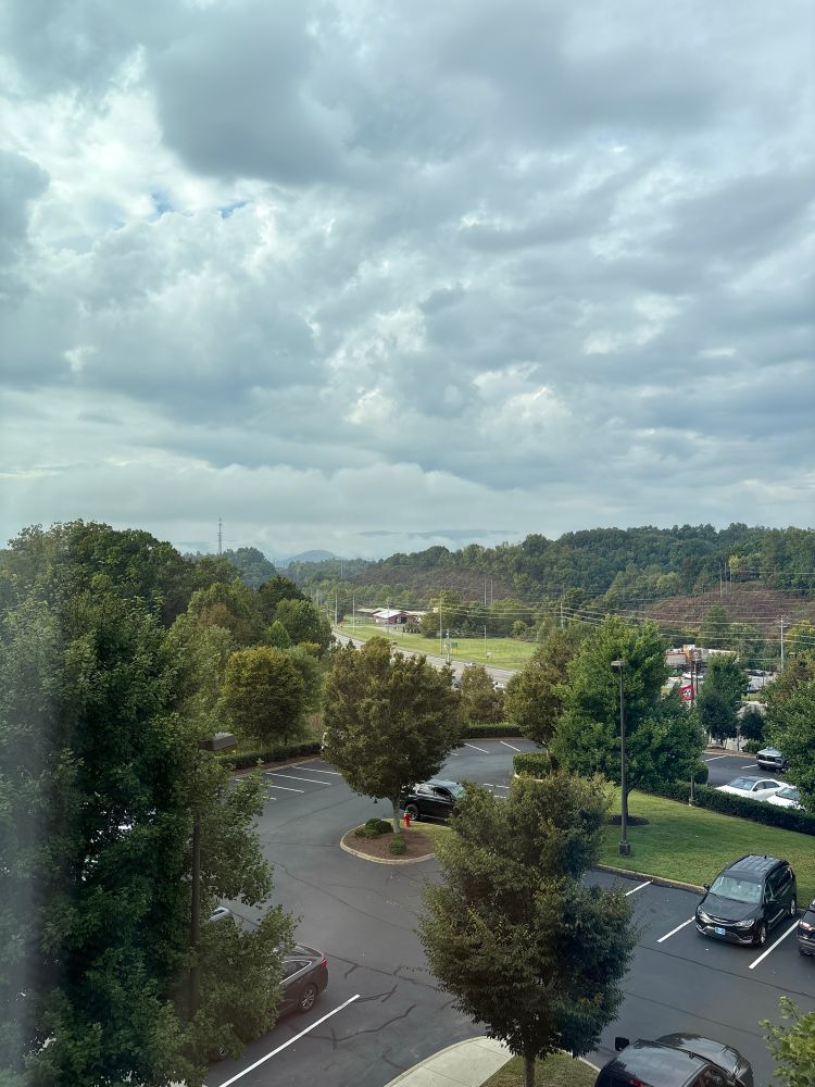 A view from our DreamMore hotel window of the smokies in the background obscured by passing clouds.  