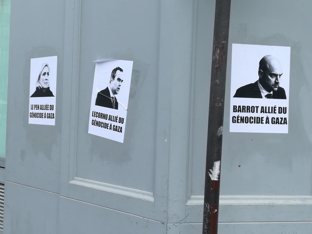 Trois affiches collées dans les rues parisiennes qui disent, "Le Pen allié du génocide à Gaza", "Lecornu allié du génocide à Gaza", "Barrot allié du génocide à Gaza"