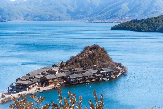 Houses clustered against the shore on a peninsula extending into Yugu Lake, Yunnan, China.  CC image by Charlottees, Pixabay.