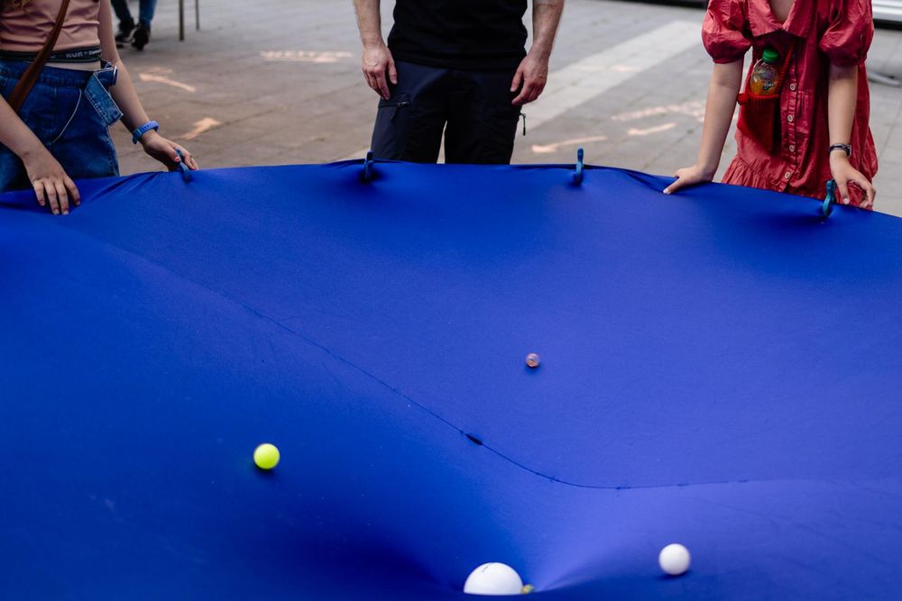 Cut-out shot of the blue cloth showing about a quarter of the circle, with more action among the various balls rolling around this time.