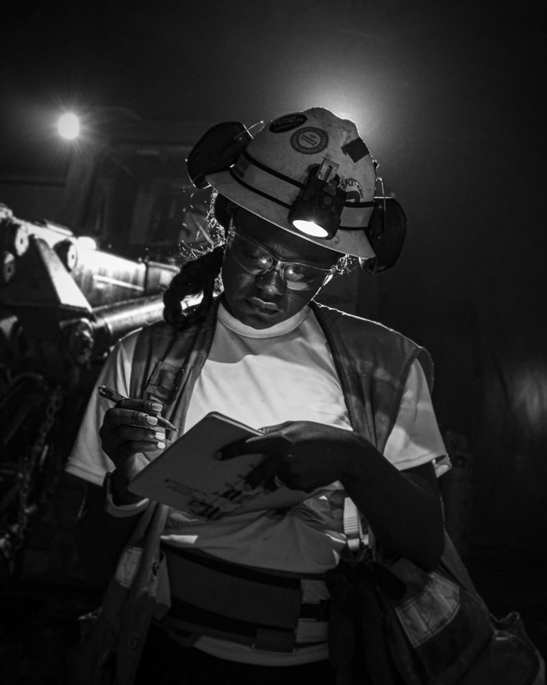 A black and white photo of a woman working in an underground zinc mine.