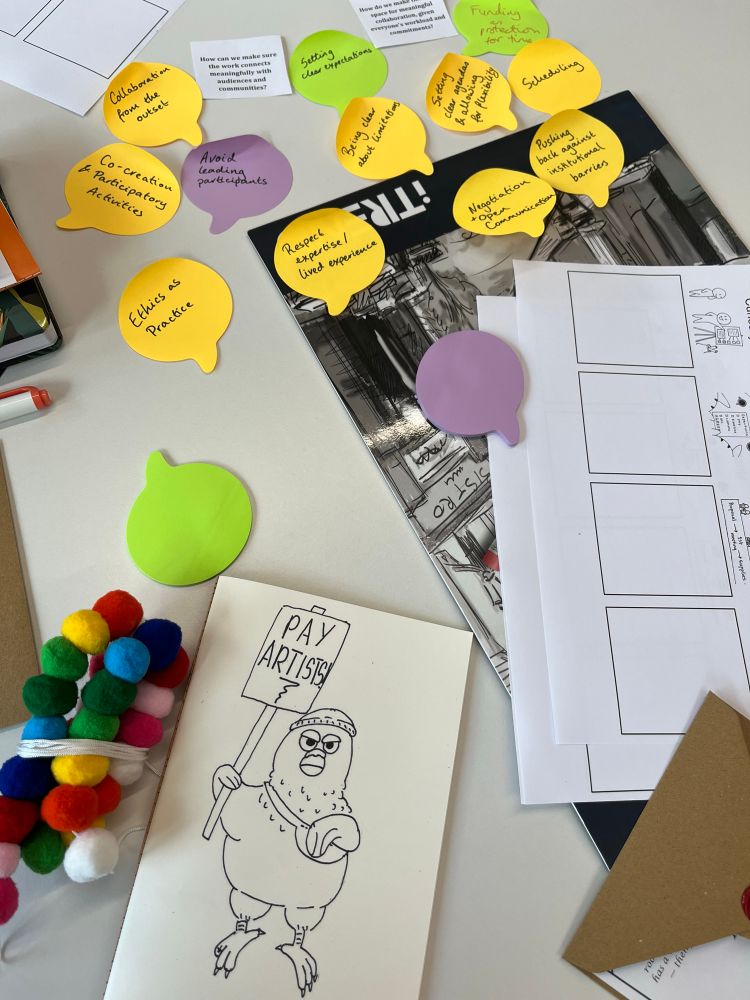 A table of stickie notes and a drawing of a pigeon with a sign that says pay artists. 