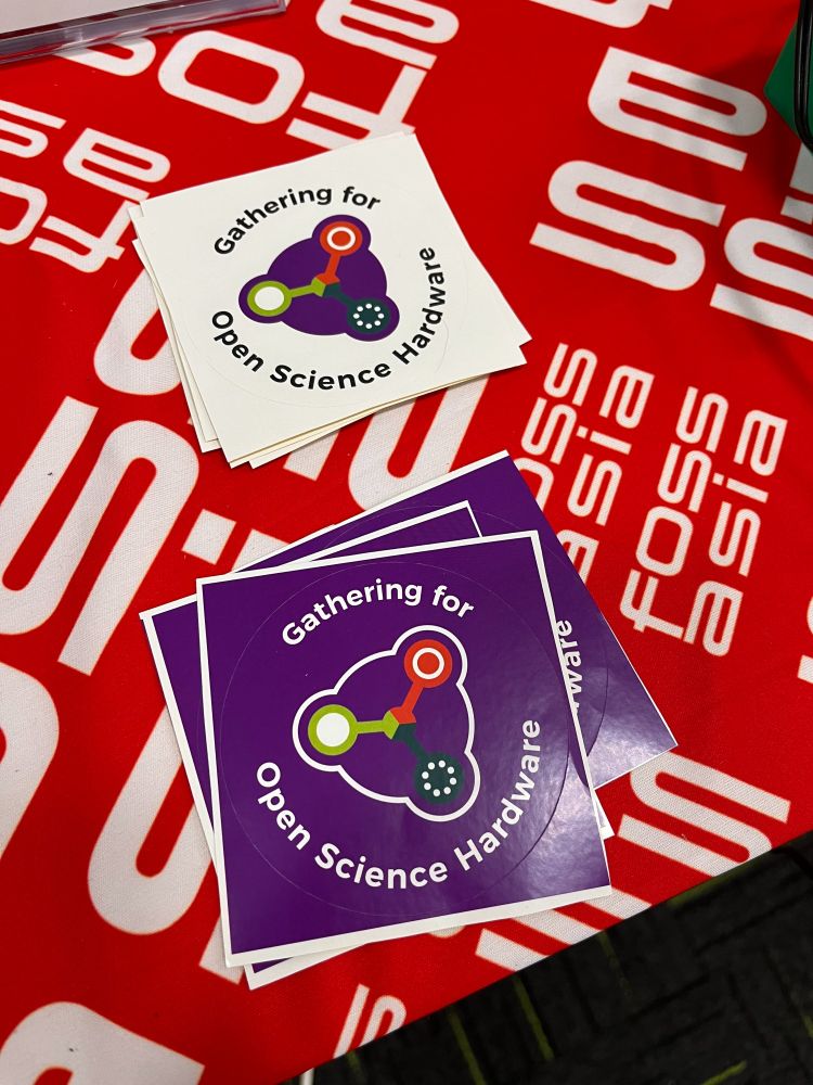 Stacks of GOSH stickers on a table top at a GOSH event