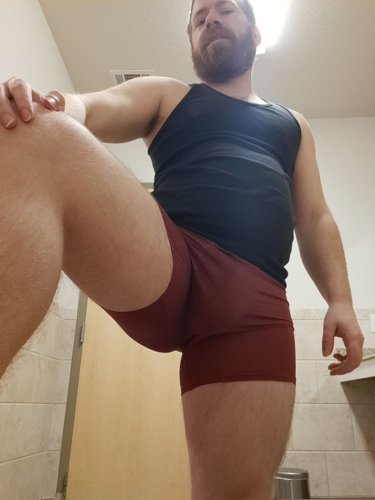 Photo of me in red boxer briefs and a black undershirt, in a gym bathroom. The view is at about crotch height, and I have one foot placed dominantly beside the camera, kind of forcing the viewer to focus on the upper legs, bulge, and belly. XD
