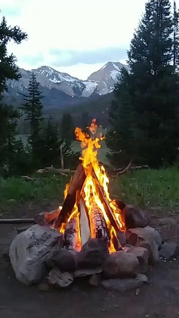 a campfire with mountains in the background