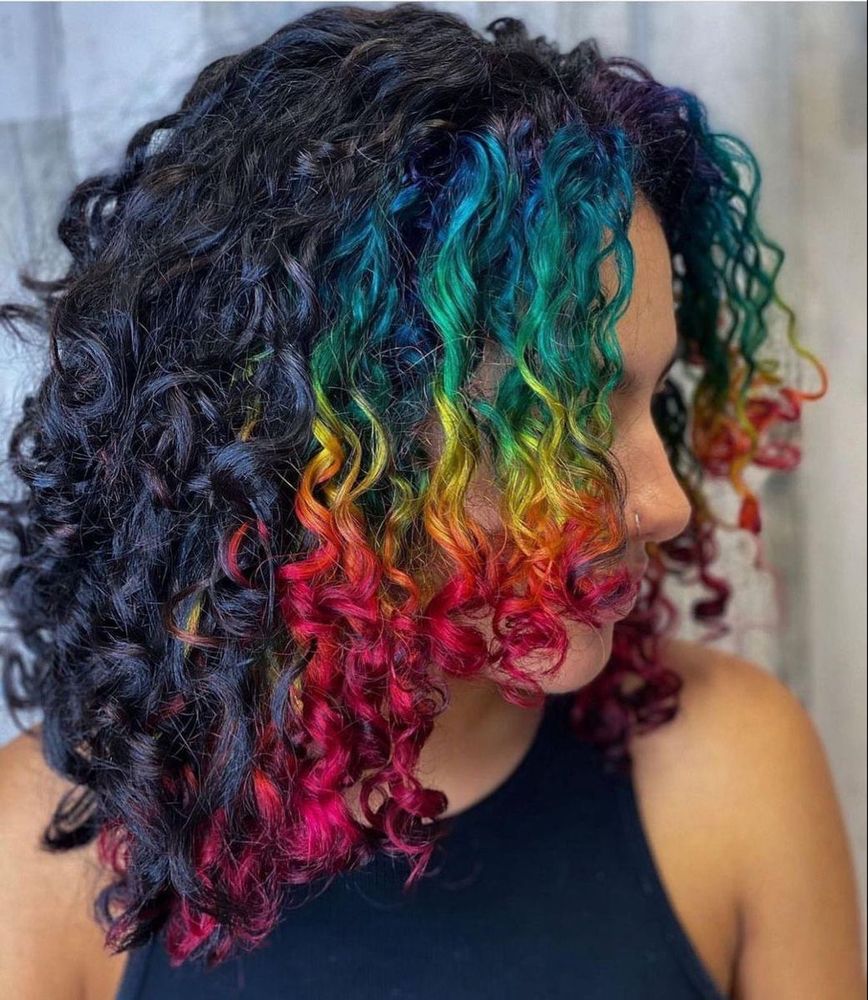 curly hair with the front section dyed like the rainbow. from tip to roots it’s red, orange, yellow, green, blue, and purple