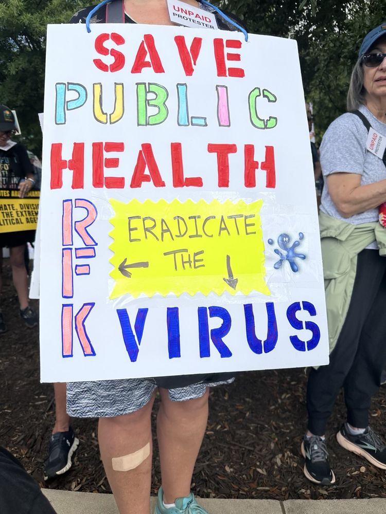 Protest sign saying, "Save Public Health, eradicate the RFK Virus"