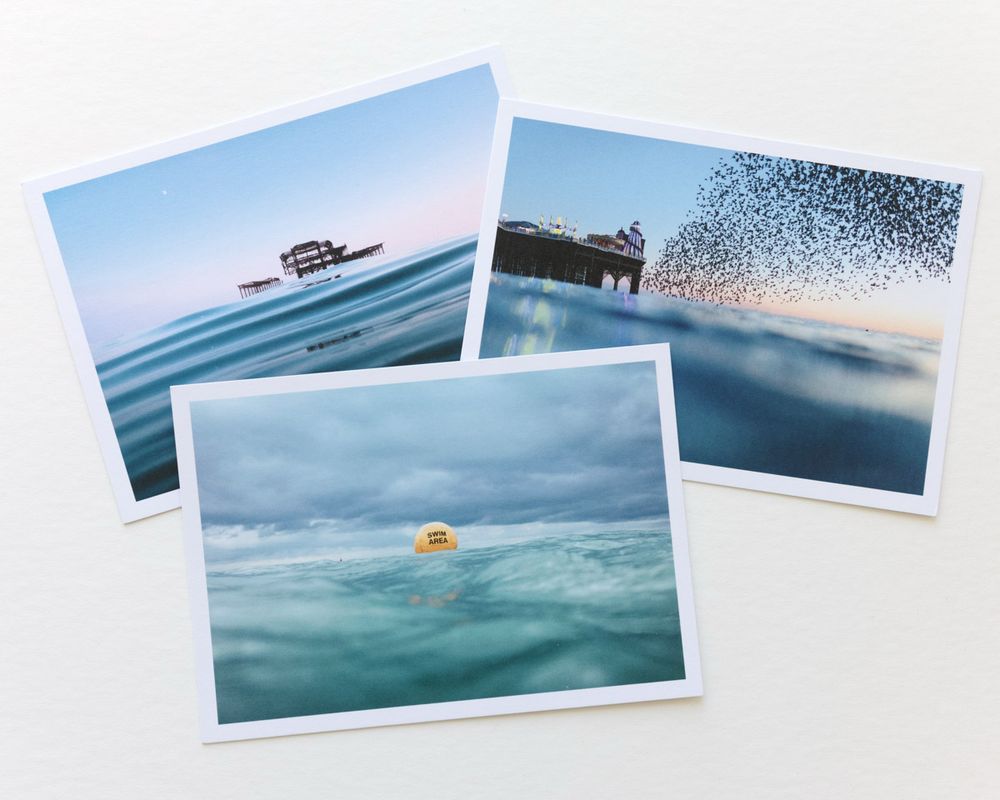 Three postcards. A6, with a different picture on each. One is a starling murmuration, one is a swim area buoy and one is the west pier. 