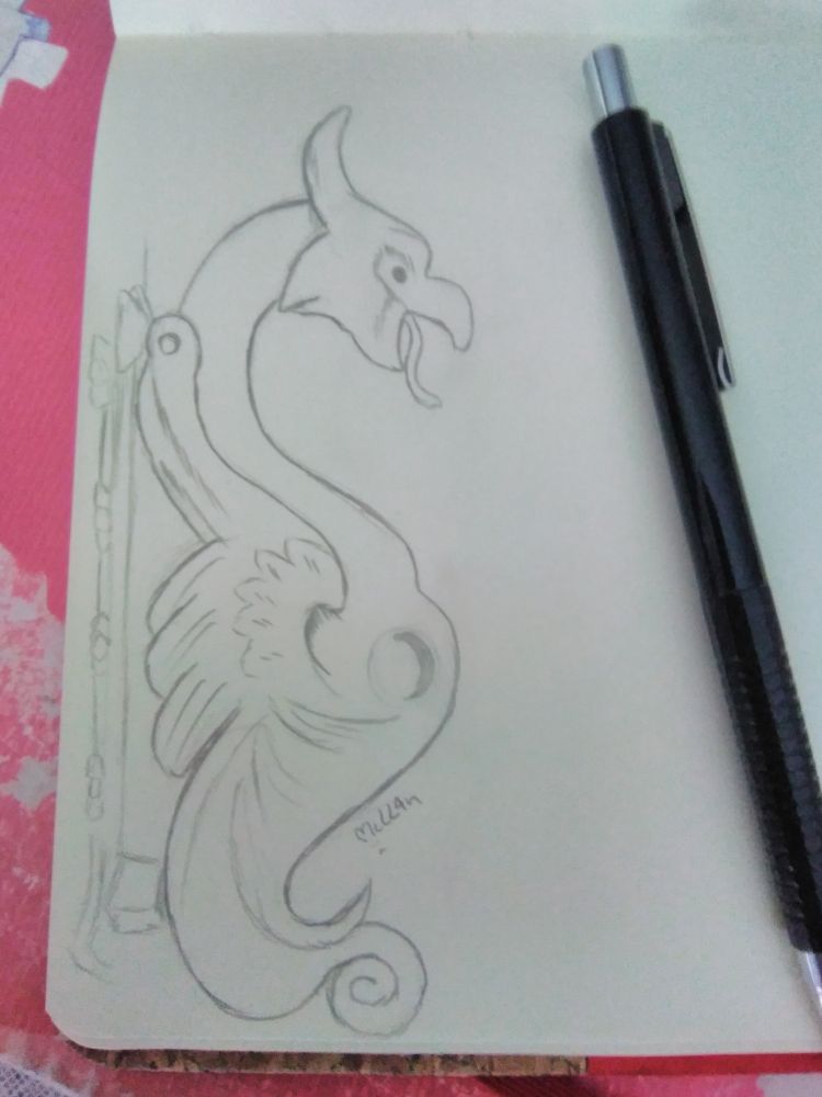 Desenho estudo de maçaneta com formato de grifo. Ao lado do desenho está um lápis de minhas preto e, por baixo do caderno está um fundo rosa