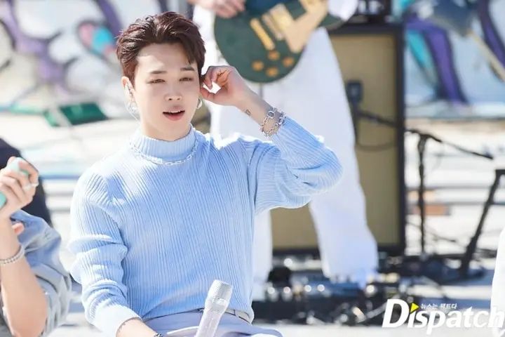 Jimin wears a baby blue mock turtleneck sweater.