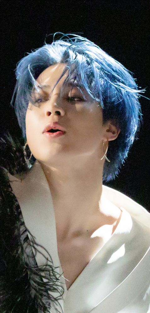 Jimin wears bright blue hair. 