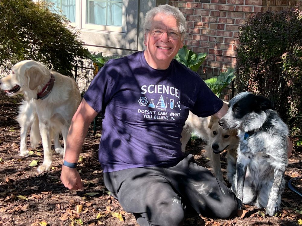 Man with dogs with "Science doesn't care what you believe in" T-shirt.