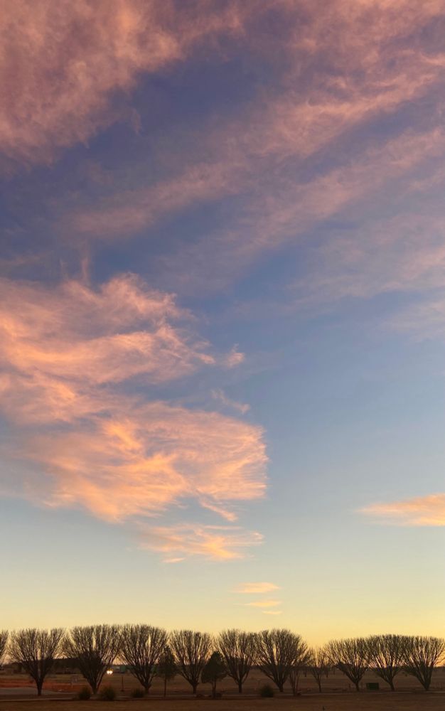 A low horizon under a large sky of blue, orange and white.
