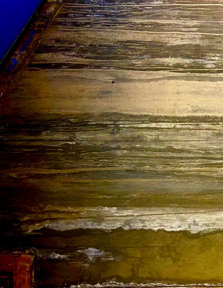 Detail of a wall in the Borough Hall MTA station in Brooklyn, NY. Wood grain and lines of worn paint create a surface that looks almost like that of a gas giant planet.
