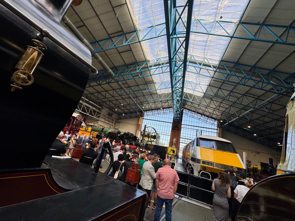 A view looking head on between other displayed locomotives towards a Class 91 locomotive in the main exhibition hall of the National Railway Museum in York. 
