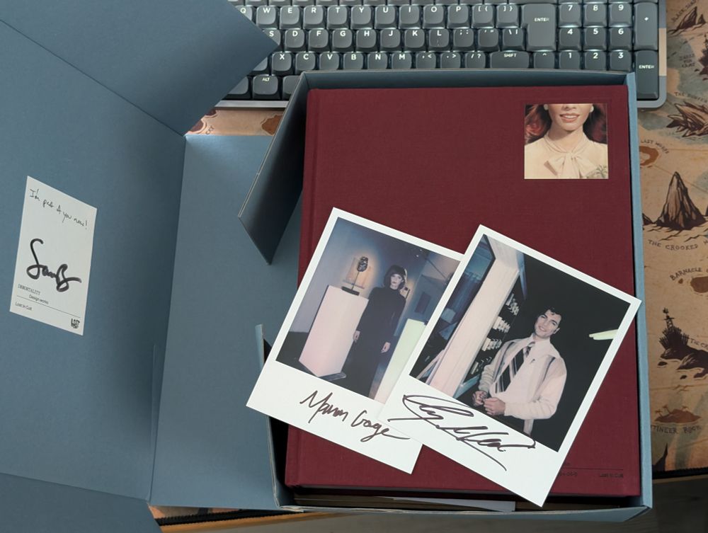 The Immortality Design Works Deluxe Edition box sitting on my desk, featuring signed "Polaroids" of Manon Gage and Ty Molbak, as well as a card signed by Sam Barlow.