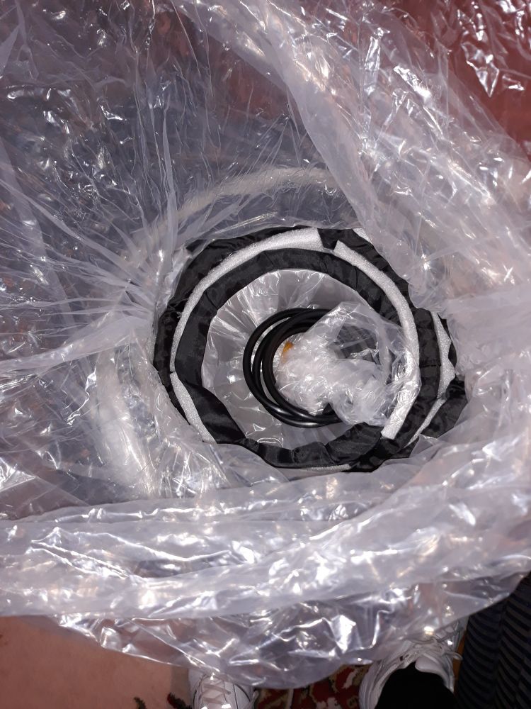 A black & white photo of clear plastic bags encasing black concentric circles roughly the same shape as the egg/eye photo, only disorganized and strange.