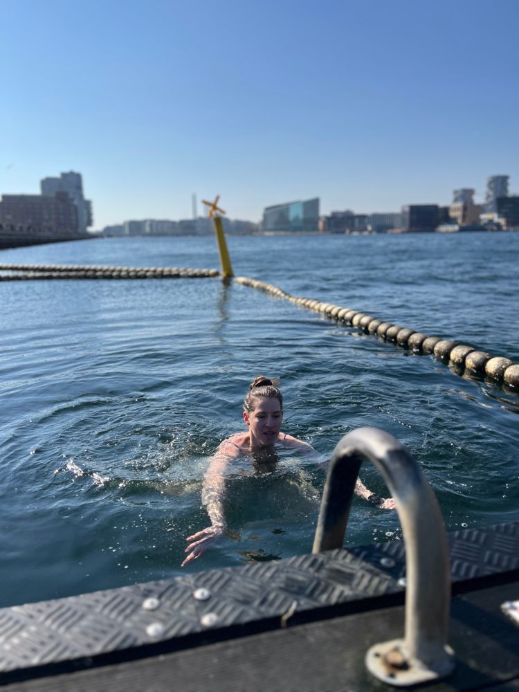 A woman (me) swimming in Copenhagen harbour on a sunny spring day
