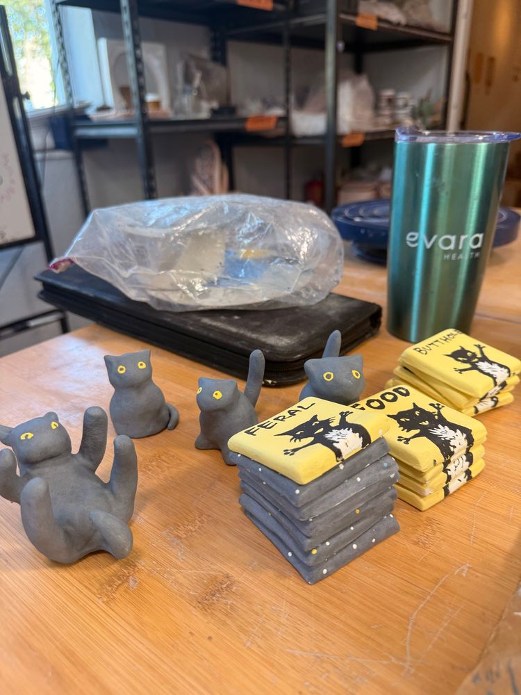 A group of clay trinkets getting ready to be glazed. There are four black cat trinkets and three stacks of magnets with black cats. Moon magnets are under obscured but a cat one on top.

#Ceramics #ClayArt #Pottery #Clay #ArtTherapy #AutisticArtist #ADHD #Sculpture #Art #Artist #cat
